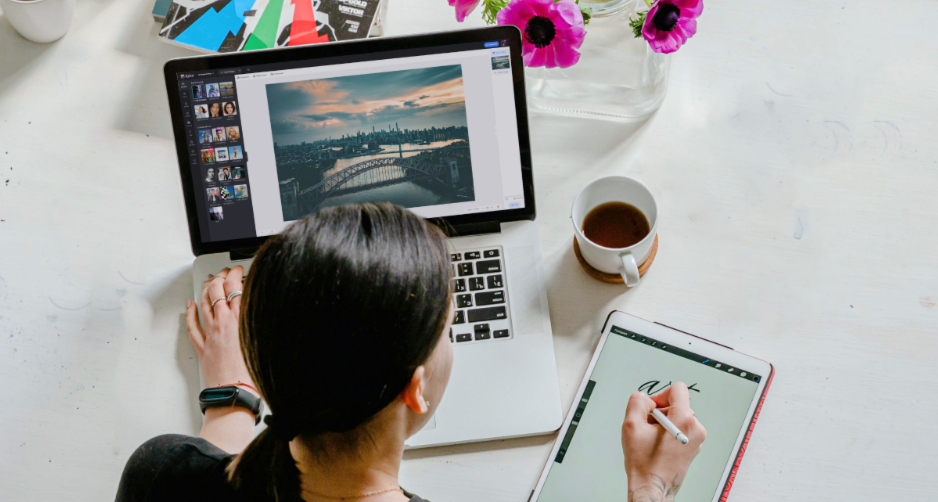 Designer femminile che crea design su un computer e un tablet usando Fotor